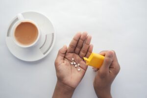 young man putting artificial sweetener in tea,