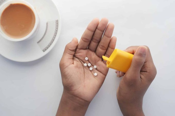 young man putting artificial sweetener in tea,